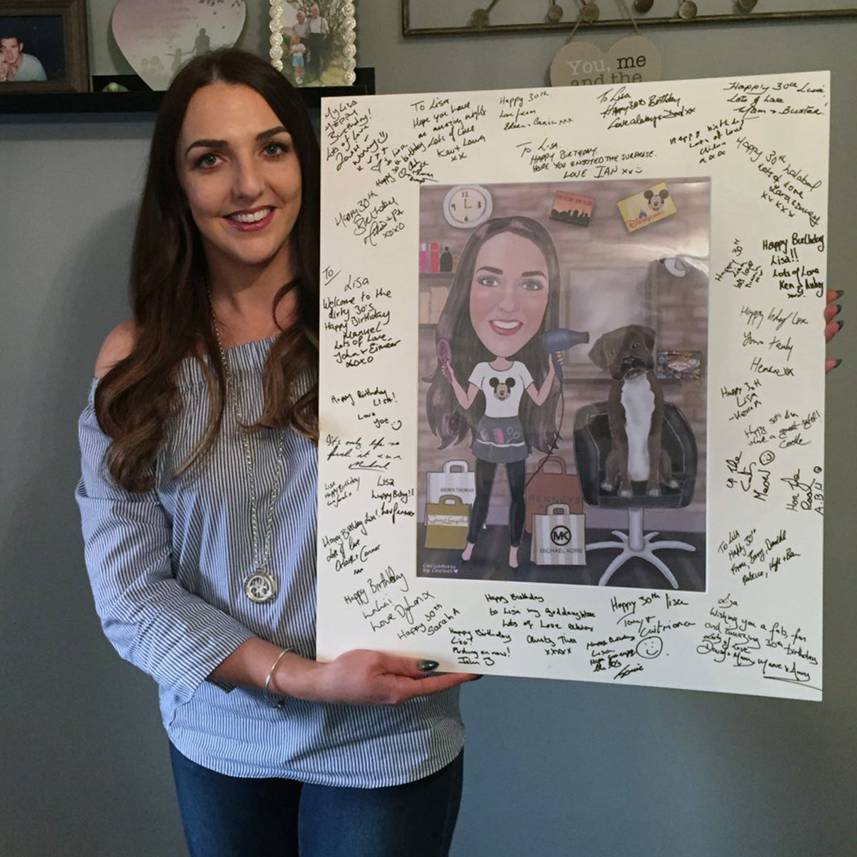Hairdresser standing with her caricature guest signing board