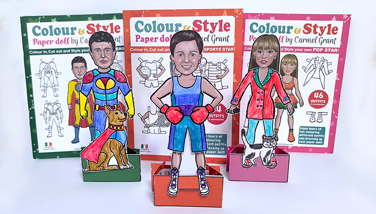 Three paper dolls standing in front of their paper doll books by Carmel Grant. Nostalgic gifts for children. website