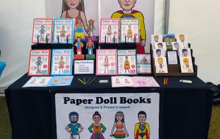 Paper Doll Books and caricature greeting cards by Carmel Grant Designs for sale at market stall
